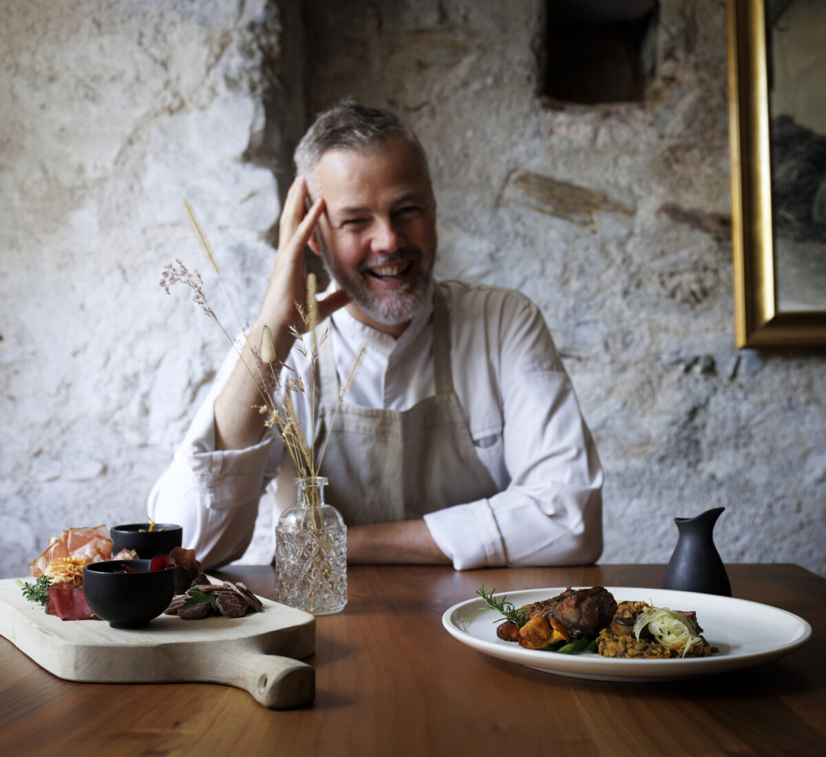 Alto Adige - Termeno - Ansitz Romani - Armin Pernstich  in sala con il suo tagliere con speck e salumi fatti in casa e coscia di agnello del Renon con lenticchie,  finferli, finocchio e fagioli